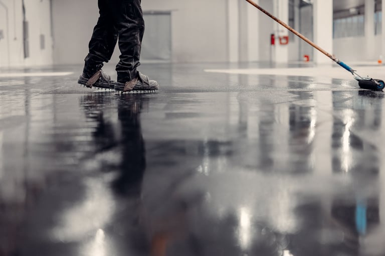 Worker applying epoxy coating in warehouse